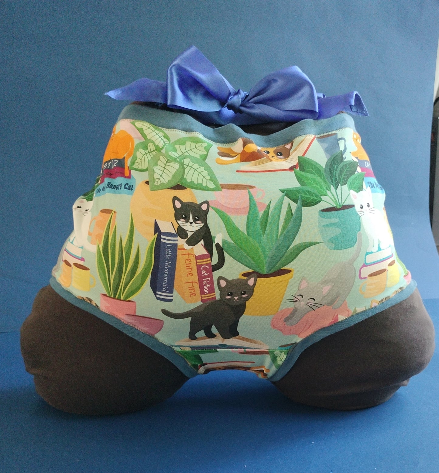 The rear of the garment with cats, houseplants, books & mugs design